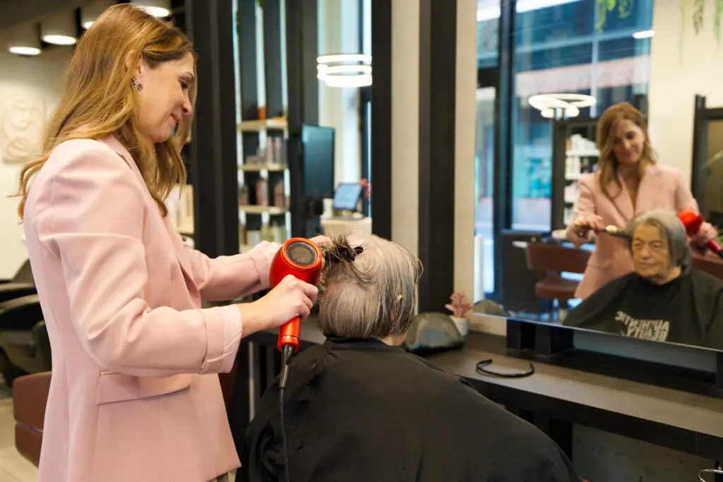 Kapper die haren brushed van klant in het salon LYSA Turnhout